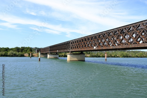 Beautiful Old Iron railway bridge Pont ferroviaire dit viaduc d'Avignon over the sparkling waters of the Rhone River near Avignon, France photo