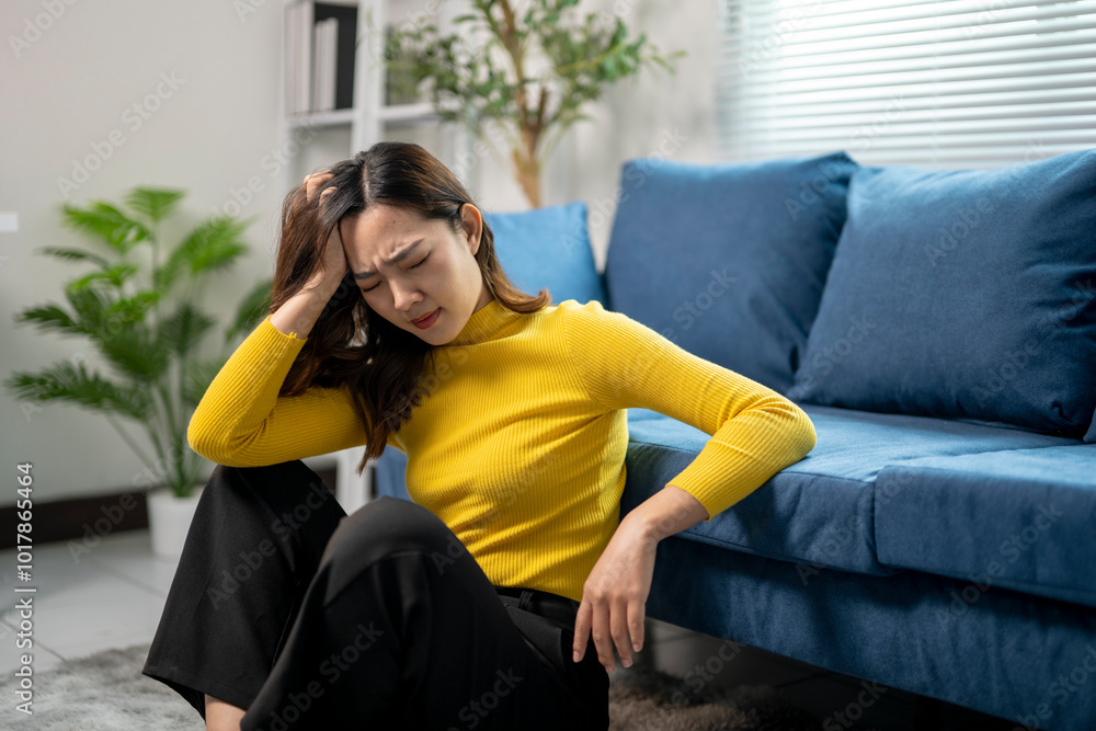 Fototapeta premium Young asian businesswoman suffering from headache at home