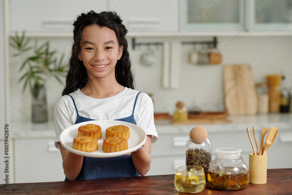 Portrait of Asian girl smiling at camera while baking homemade cakes at home Portrait of Asian girl smiling at camera while baking homemade cakes at home