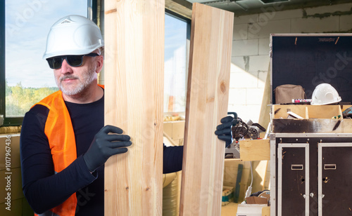 Man builder holding planks....