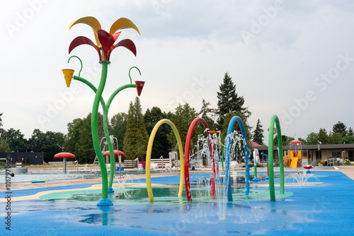 Vibrant outdoor water playground featuring colorful sprinklers and play structures, perfect for summer fun and family activities. High quality photo