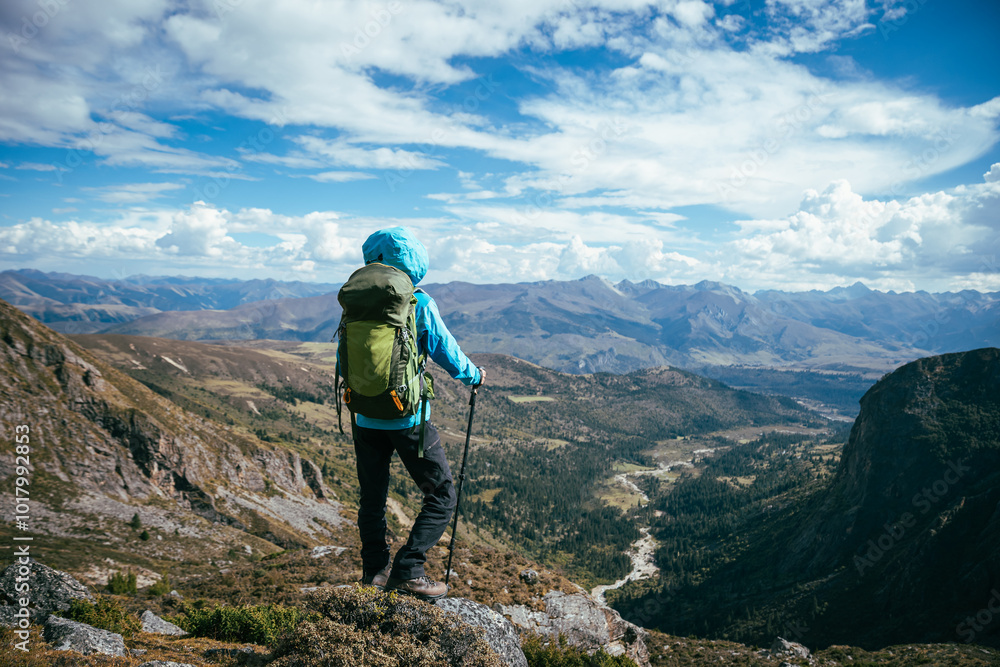Backpacking woman climbing up on steep cliff edge at high altitude mountains top Backpacking woman climbing up on steep cliff edge at high altitude mountains top
