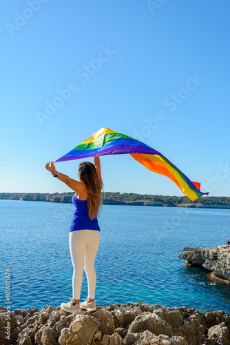 woman, middle aged, outdoors waving pride flag, concept of libertat, equality photo