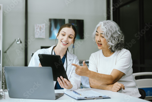 medicine, healthcare and people concept - doctor with tablet pc computer talking to woman patient at hospital.