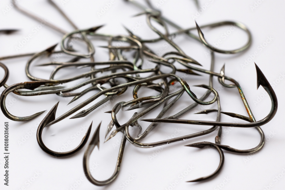 Man is fishing with hooks in white on . hook catch concept. man is fishing with barbed wire hook on a white . a barbed wire fishing hook with a white and a tan striped lifestyle.