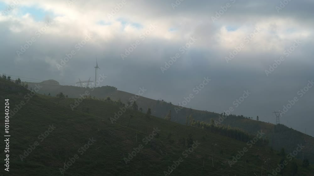 Aerogerador (Wind turbine) on top of a mountain, in a cloudy day, at sunrise Aerogerador (Wind turbine) on top of a mountain, in a cloudy day, at sunrise