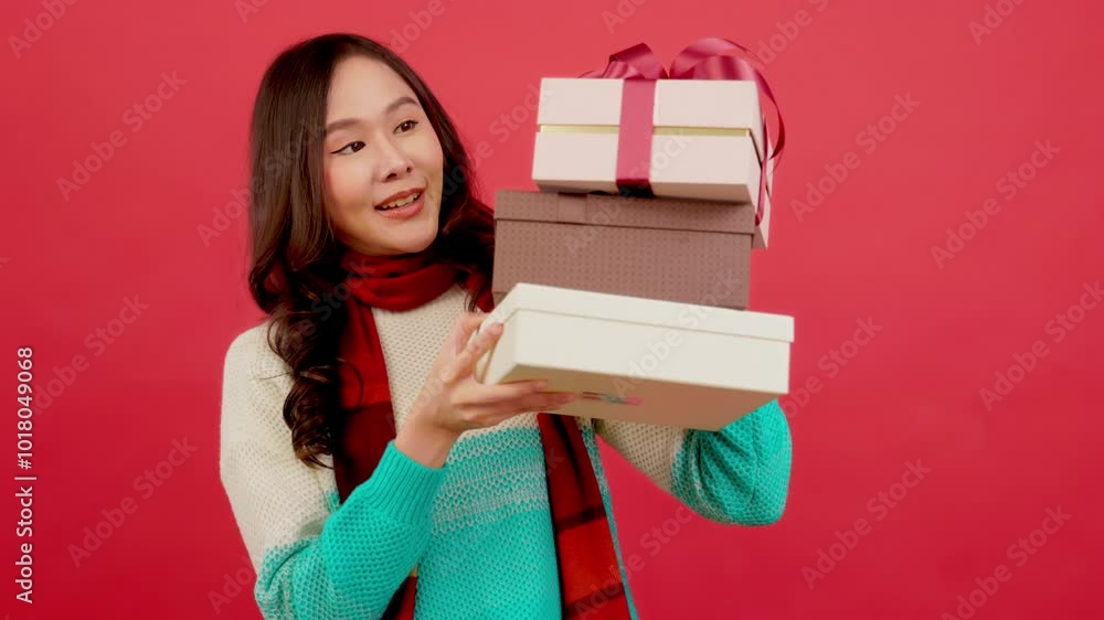 Happy smiling asian woman holding gift box over red background Happy smiling asian woman holding gift box over red background