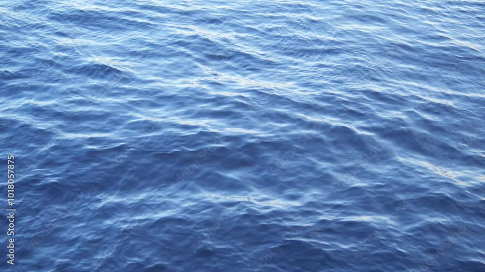 The calm and serene blue ocean waves gently lap at the surface, creating a beautiful scene The calm and serene blue ocean waves gently lap at the surface, creating a beautiful scene
