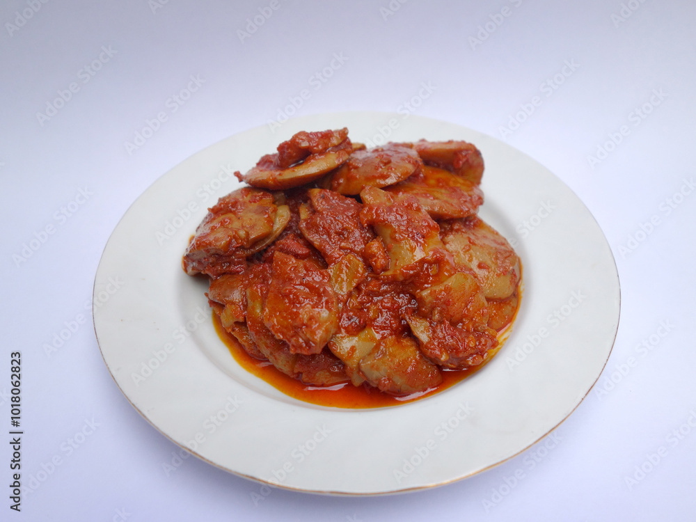 Jengkol Balado or dogfruit with red chili sauce, a spicy traditional Indonesian dish from West Sumatra, served on a white plate with a clean white background Jengkol Balado or dogfruit with red chili sauce, a spicy traditional Indonesian dish from West Sumatra, served on a white plate with a clean white background