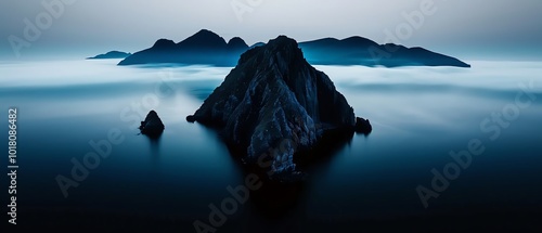 Vintage-style rocks in the middle of the sea, mist swirling around them, fading light of a nostalgic evening