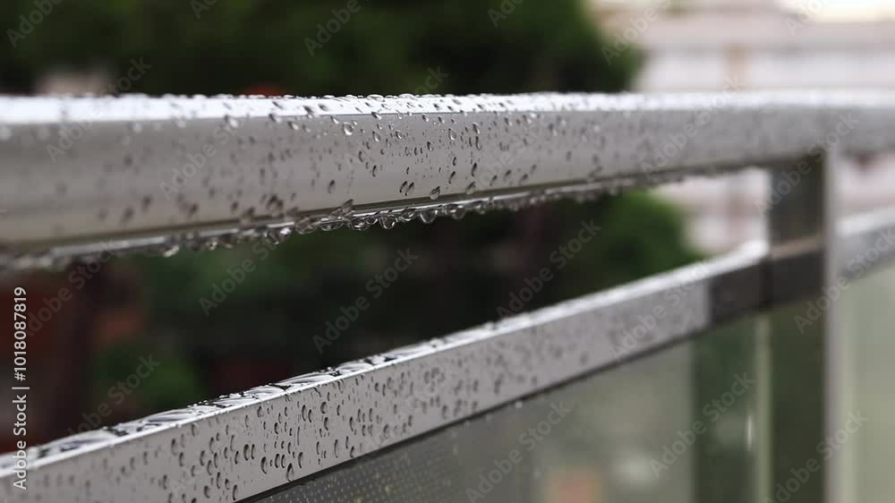 Balcony railings in the rain, selective focus. Close-up of balcony railing with raindrops, wet balcony. Raindrops falling on balcony railings. Water drops Balcony railings in the rain, selective focus. Close-up of balcony railing with raindrops, wet balcony. Raindrops falling on balcony railings. Water drops