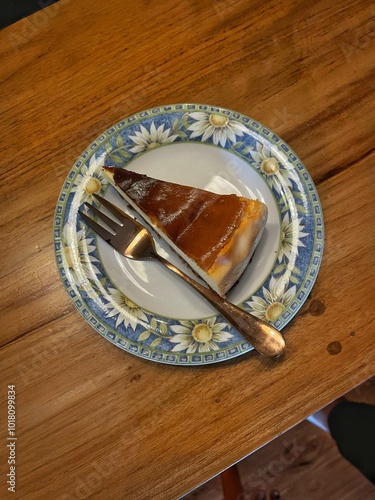 Basque burnt cheesecake slice on decorative plate.