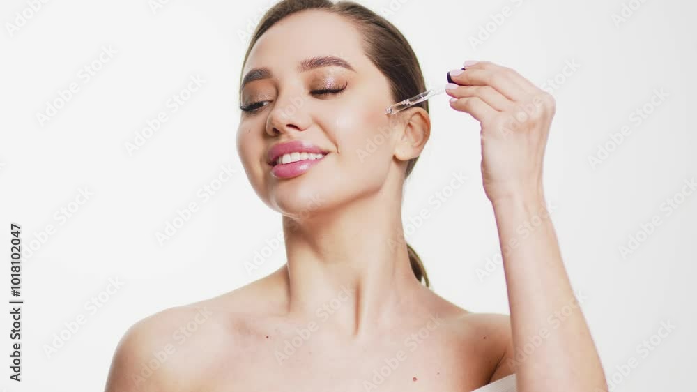 A close-up of a young woman applying serum from a pipette to her skin. This moment showcases the use of a natural organic cosmetic product for facial skin care and regeneration. A close-up of a young woman applying serum from a pipette to her skin. This moment showcases the use of a natural organic cosmetic product for facial skin care and regeneration.