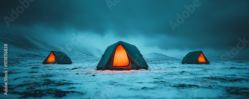 Windproof tents glowing with warm light, set in a snowy landscape, winter camping in cold and windy weather photo