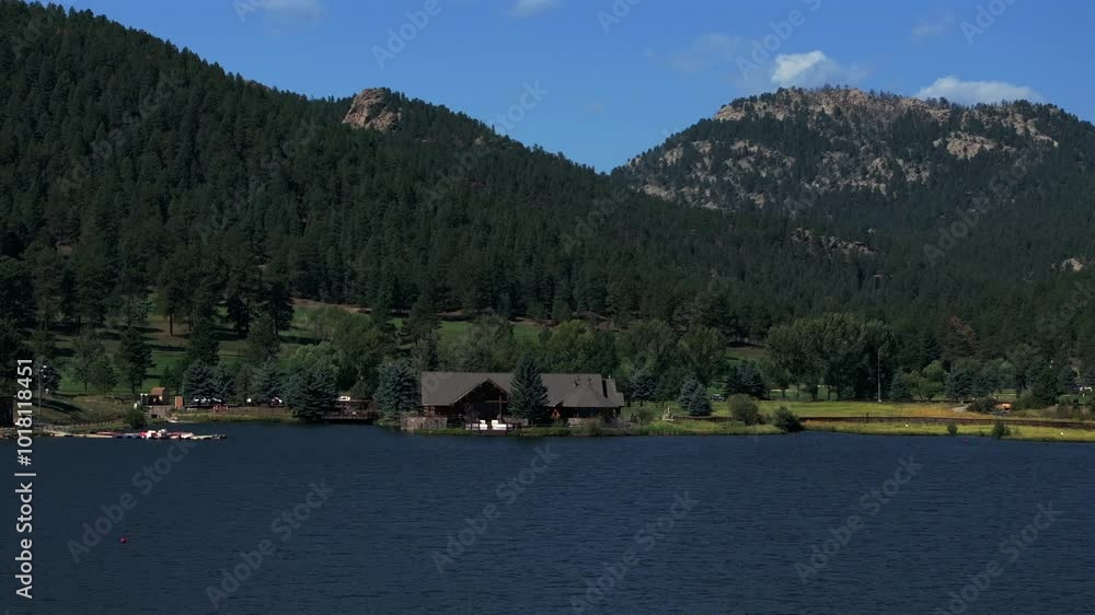Evergreen Lake House Park and Rec Center Golf Course Keys on the green down town mountain town blue sky summer sunny paddle boarding fishing Colorado three sisters rocks aerial drone forward motion Evergreen Lake House Park and Rec Center Golf Course Keys on the green down town mountain town blue sky summer sunny paddle boarding fishing Colorado three sisters rocks aerial drone forward motion