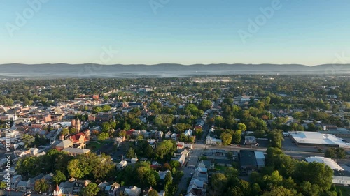 Aerial view of Carlisle, PA, showcasing a mix of residential, commercial buildings, and tree-lined streets under a clear morning sky.