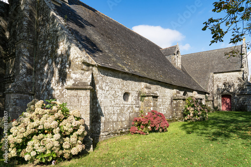 La Chapelle Saint-Côme & Saint-Damien, sous un ciel bleu radieux, est bordée d'hortensias en fleurs, créant un tableau enchanteur en plein été dans le Finistère photo