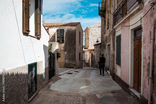 A man strolls through the historic centre of a village in sardinia