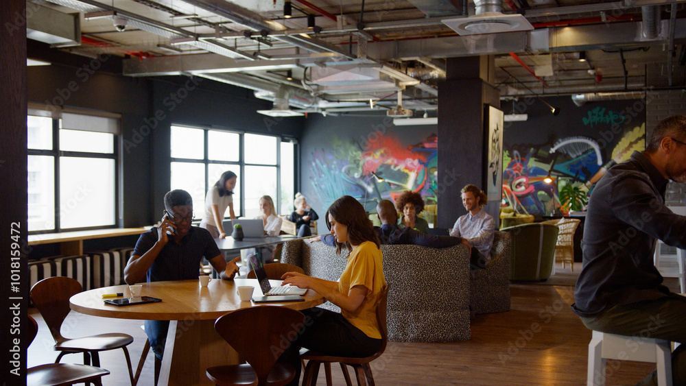 Informal Meeting Area In Modern Office With Businesspeople Meeting And Working At Tables Informal Meeting Area In Modern Office With Businesspeople Meeting And Working At Tables