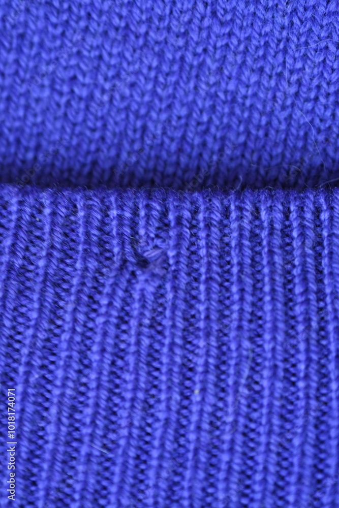 Obraz premium Close-up of a darned hole in a purple woollen fabric, darned hole in a sweater 