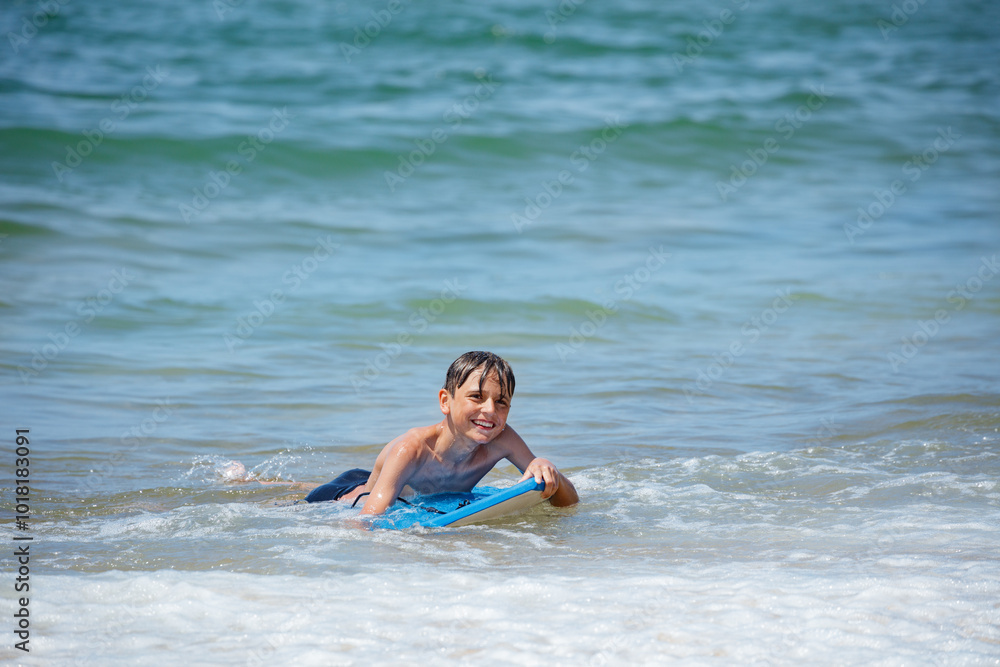 A youngster plays on boogie board at the seaside wait for wave A youngster plays on boogie board at the seaside wait for wave