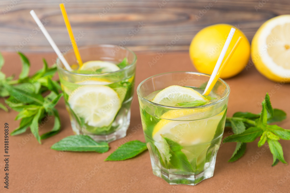 Fototapeta premium Mojito summer refreshing cocktail with ice and mint. mojito cocktail with lime, lemon and mint in a tall glass with a stick