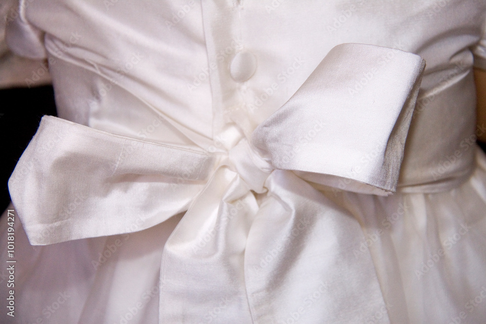 Back lacing of white children's dress with buttons. You can see the texture of the fabric Back lacing of white children's dress with buttons. You can see the texture of the fabric