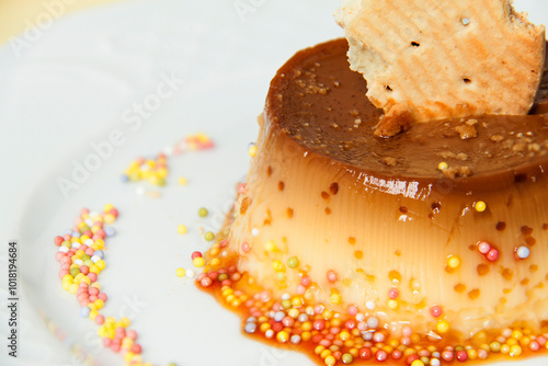 Fragment of a plate with flan with a portion of biscuit and sugar shavings around it