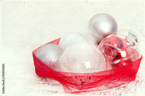Christmas card landscape. Christmas ball center with red bow on the right side. Background with blurred silver details