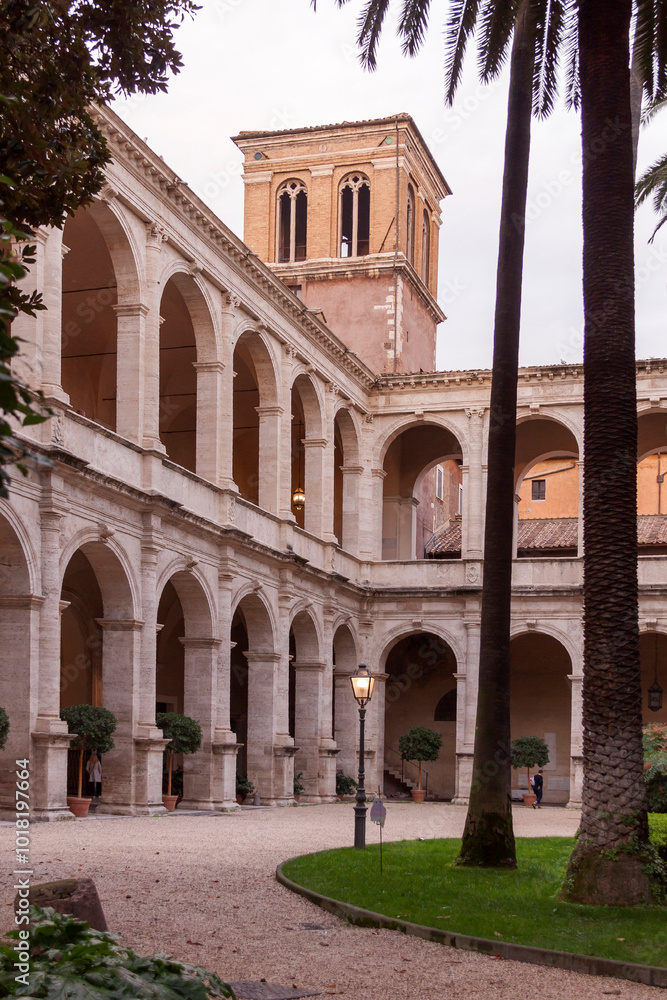 Entrance to the ecclesiastical enclosure with arches, columns and palm trees in the city of Rome Entrance to the ecclesiastical enclosure with arches, columns and palm trees in the city of Rome