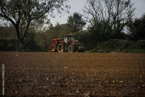 Harvest time  Tractor  waitss  n the  field  in the  event  autumn sun 