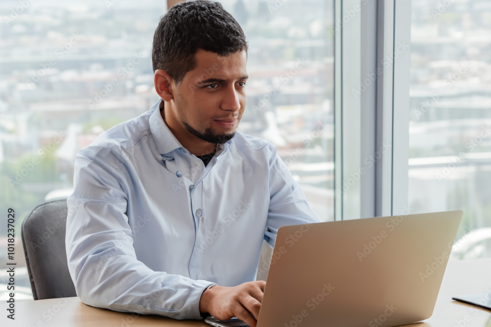 Man is working on his laptop at desk. office technology computer concept. man is sitting at table with laptop. a man is sitting at a desk with a laptop and a lifestyle table for business. Man is working on his laptop at desk. office technology computer concept. man is sitting at table with laptop. a man is sitting at a desk with a laptop and a lifestyle table for business.