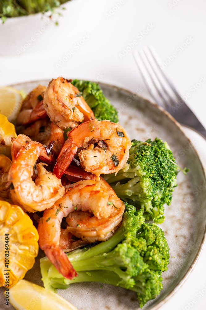 Shrimp and vegetables cooked in the oven for a healthy lunch on a white table Shrimp and vegetables cooked in the oven for a healthy lunch on a white table