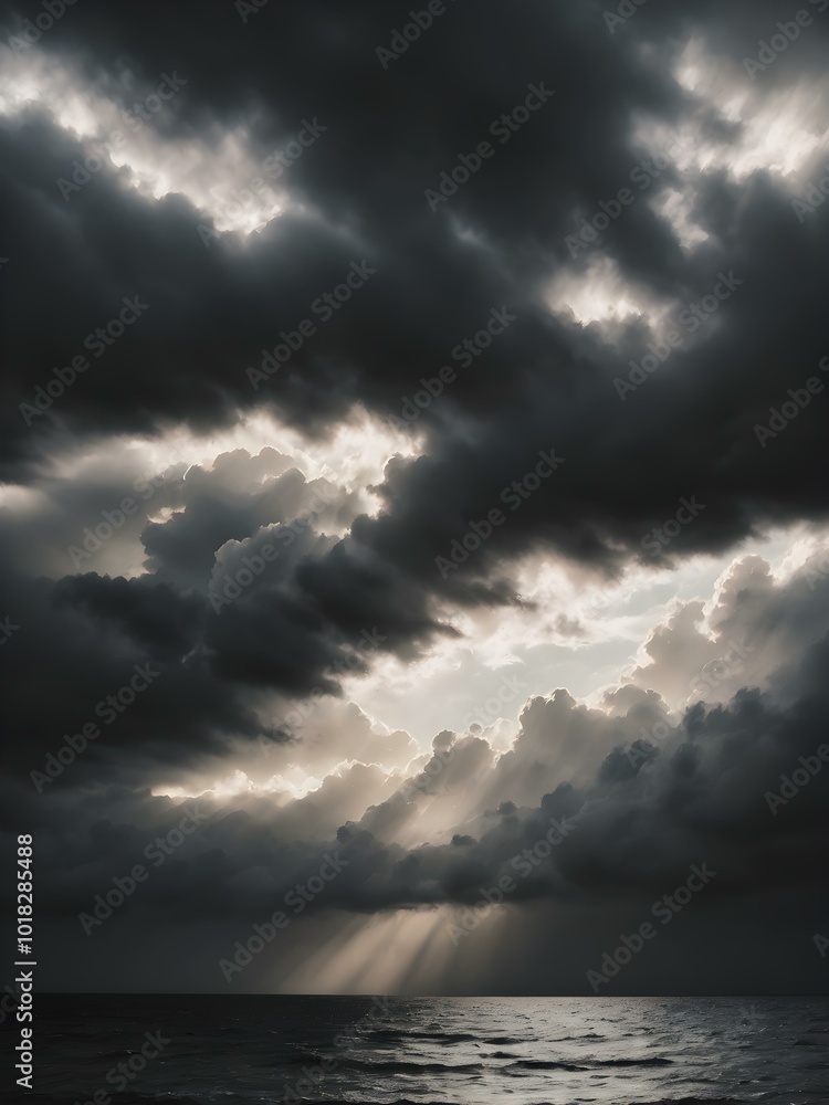 Obraz premium A moody sky with heavy gray clouds and soft sunlight peeking through, creating a dramatic contrast between light and shadow 