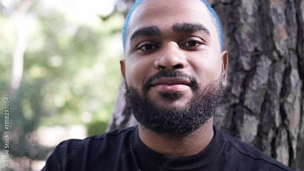 Black african american man sitting under a tree looking proudly and confident at camera, close-up portrait.MOV Black african american man sitting under a tree looking proudly and confident at camera, close-up portrait.MOV