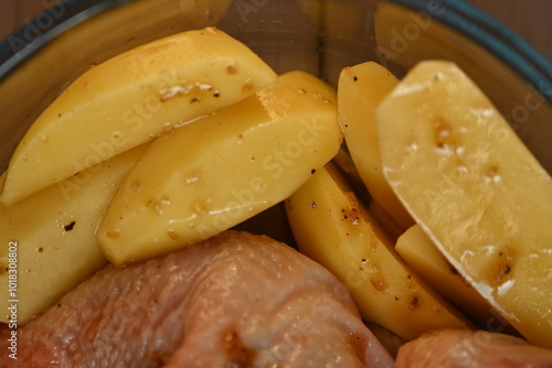 marinated chicken  and potatoes in sauce in a dish before baking, the texture of potatoes and meat cooked for dinner  photo