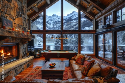 Cozy Vail living room with stone fireplace, pool table, and snow-capped mountain views for a winter vacation.