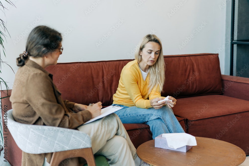 Obraz premium A female client at a session with a psychologist cries and talks about her problems.