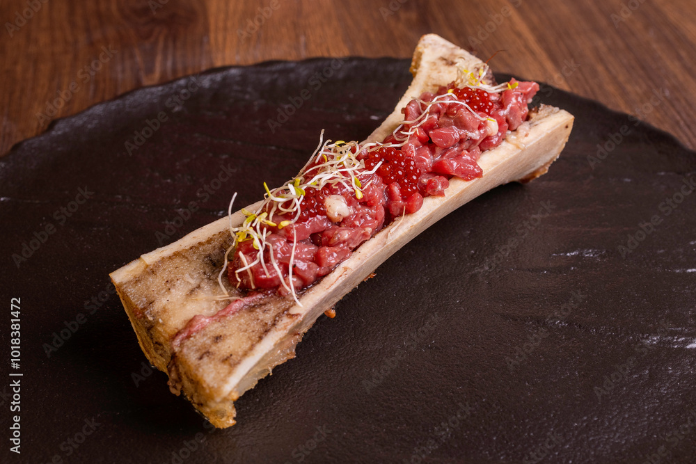Tartare di carne condita e speziata servita su un osso in una braceria Tartare di carne condita e speziata servita su un osso in una braceria