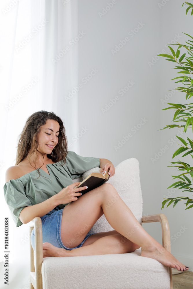 Young woman reading an interesting book. The young man entertains himself by reading a book. He smiles because he likes the story of the book and imagines the protagonists. Dream, imagine. Young woman reading an interesting book. The young man entertains himself by reading a book. He smiles because he likes the story of the book and imagines the protagonists. Dream, imagine.