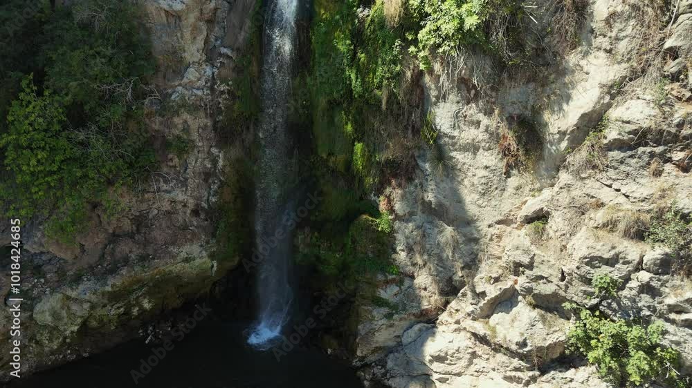 Drone Shot, Water Cascading Over Rocky Cliff Creates Stunning Waterfall, Surrounded by Vibrant Greenery and Lush Vegetation, Beauty of Nature in Serene, Tranquil Setting . Aerial view Drone Shot, Water Cascading Over Rocky Cliff Creates Stunning Waterfall, Surrounded by Vibrant Greenery and Lush Vegetation, Beauty of Nature in Serene, Tranquil Setting . Aerial view