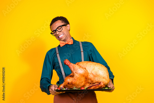 Photo of tired guy prepare heavy chicken meat dish for thanksgiving day isolated yellow color background