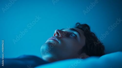 Stressed individual lying awake in bed