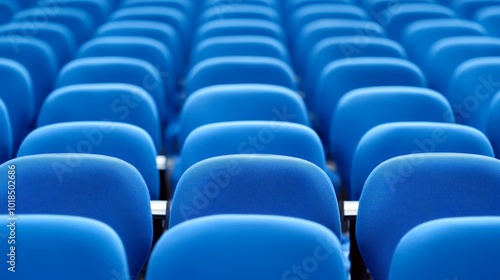 A row of blue conference chairs aligned neatly in an auditorium setting.