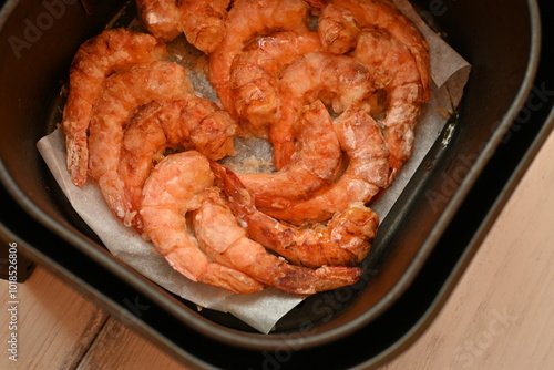 cooked shrimps without shells in aero grill, tasty healthy food concept, baked seafood in breading, European cuisine, fried cooked shrimp tails fried in clary close-up	
 photo