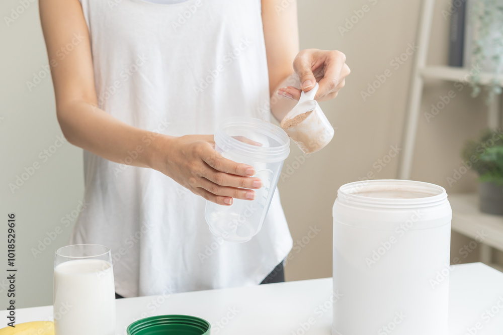 Diet meal replacement for weight loss, asian young woman in sportswear, hand in holding scoop making protein into bottle to shake, drink supplement for muscle after workout at home. Healthy body care. Diet meal replacement for weight loss, asian young woman in sportswear, hand in holding scoop making protein into bottle to shake, drink supplement for muscle after workout at home. Healthy body care.