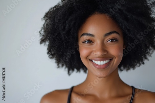 a Black African woman with natural, curly hair and a broad smile. This image emphasizes her poised demeanor and confidence, perfect for business or branding purposes.