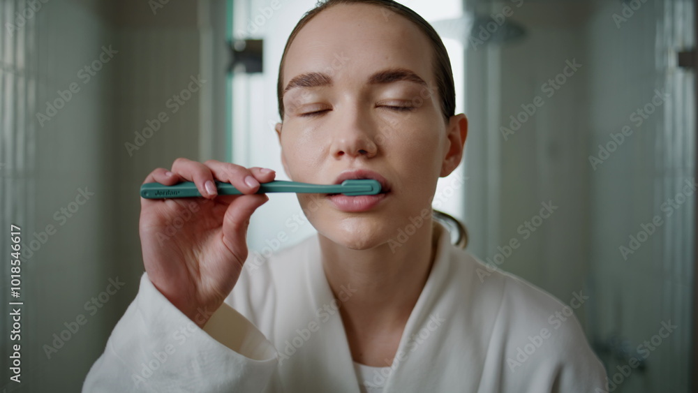 Young woman brushing teeth at home closeup. Pretty girl looking camera cleaning Young woman brushing teeth at home closeup. Pretty girl looking camera cleaning