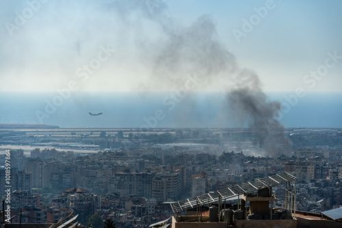 A plane taking off from Beirut International Airport as smoke rises from airstrike on Beirut southern suburbs, amid ongoing war between Hezbollah and Israel in October 2024