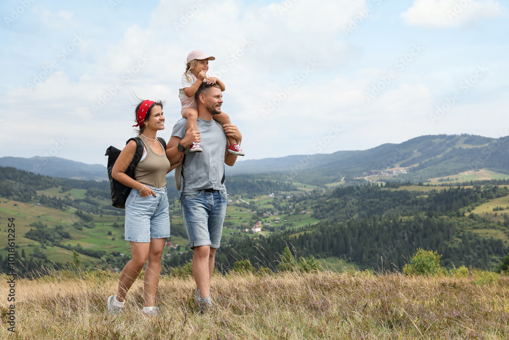 Happy family with backpacks travelling in mountains, space for text. Active tourism Happy family with backpacks travelling in mountains, space for text. Active tourism